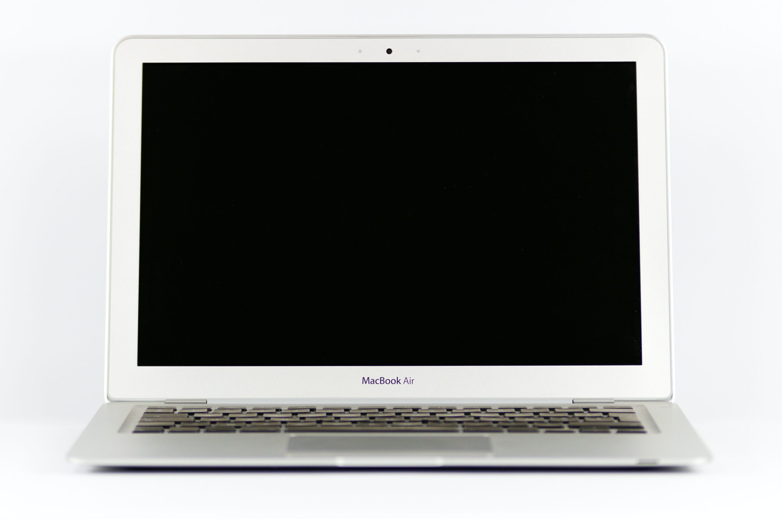 Otwarty laptop z czarnym ekranem na białym tle